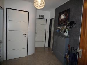 a kitchen with white cabinets and a white door at Private Apartment Laatzen City in Hannover