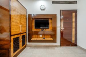 a living room with a tv and a wall at Royal Residency 610 Golf View in Gurgaon