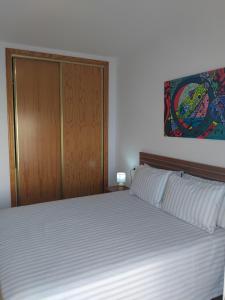 a bedroom with a large bed with a wooden door at EDIFICIO SANTA GEMA 2k in La Cala de Mijas