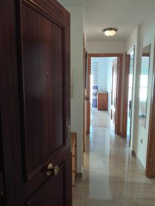 a hallway with a wooden door and a hallway leading to a room at EDIFICIO SANTA GEMA 2k in La Cala de Mijas +2 photos