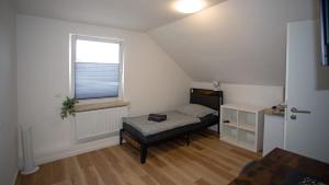 a small bedroom with a bed and a window at Cesar Apartments in Wathlingen