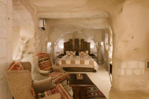 a bedroom with a bed and a table and chairs at Cappadocia Cave Suites in Göreme