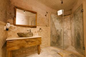 a bathroom with a sink and a shower at Cappadocia Cave Suites in Göreme