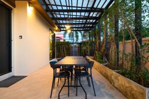 a table and chairs on a patio with trees at Modern Spacious 3-bed Ban Amphur Pool Villa (BA1) in Na Jomtien