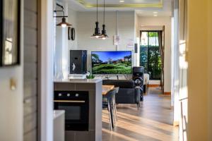 a kitchen and living room with a tv and a couch at Modern Spacious 3-bed Ban Amphur Pool Villa (BA1) in Na Jomtien