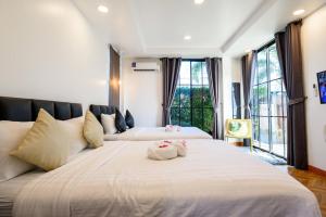 two beds in a room with large windows at Modern Spacious 3-bed Ban Amphur Pool Villa (BA1) in Na Jomtien +92 photos