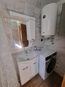 a white bathroom with a sink and a mirror at River Zen House in Šipovo