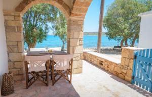 an outdoor table with a view of the ocean at The Rock Seaside House - Etheras Properties in Kythira