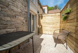 a patio with a bench and a fence at Les clés Bélinéenes in Bligny-lès-Beaune