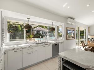 a kitchen with white cabinets and two windows at Fairview in Rosebank