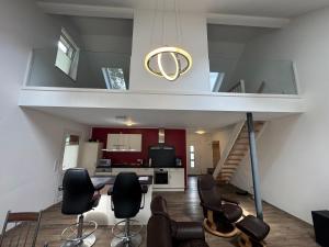 a living room with a staircase and chairs in a house at Loft Hesel, 35232 in Hesel +11 photos