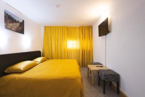 a hotel room with a yellow bed and a table at Casa Galbena Paflora Saturn in Saturn