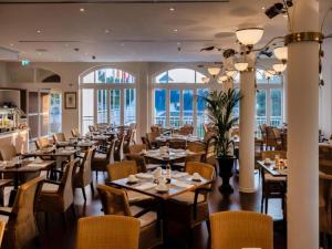 a restaurant with tables and chairs and windows at Sunday Schwielowsee Resort - Apartment in Werder