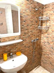 a bathroom with a sink and a brick wall at Casa Galbena Paflora Saturn in Saturn +8 photos