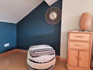 a bedroom with a blue wall with a mirror and a dresser at Chambre de Camille à Gerpinnes in Gerpinnes