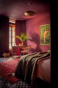 a purple room with a bed and a table at The Mellah Hotel in Marrakesh +57 photos