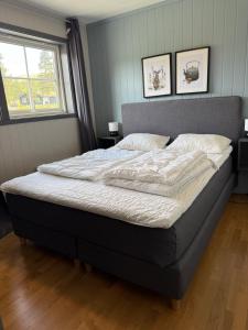 a bed in a bedroom with two pictures on the wall at Lemonsjøen, Jotunheimen in Vaga