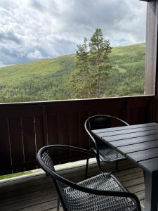 a table and two chairs on a balcony with a view at Lemonsjøen, Jotunheimen in Vaga