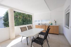 a kitchen with a table and chairs and a window at Babulje in Ulcinj