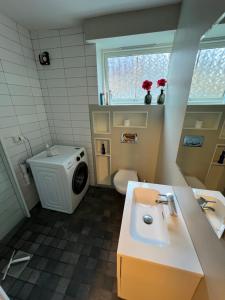 a bathroom with a sink and a washing machine at Bergen City hostel Rooms in Bergen