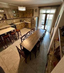 a large kitchen with a wooden table and chairs at Hill House in Kazbegi