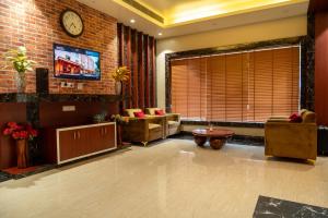 a living room with a couch and a clock on a brick wall at Odissey Suites in Bhubaneshwar