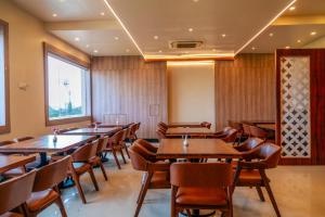 a dining room with wooden tables and chairs at Odissey Suites in Bhubaneshwar