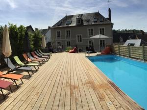 a deck with chairs and a swimming pool and a house at L'Escale de Broglie in Broglie