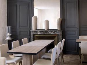 a dining room with a table and white chairs at L'Escale de Broglie in Broglie