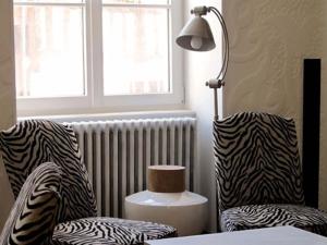 a room with a lamp and two zebra print chairs at L'Escale de Broglie in Broglie