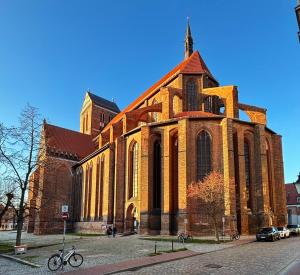 a large brick church with a bike parked in front of it at Dat Kleenood in Wismar