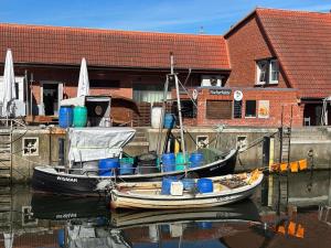 two boats are docked in the water near a building at Dat Kleenood in Wismar
