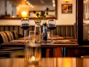 four glasses of wine on a table in a restaurant at Sunday Schwielowsee Resort - Hotel in Werder