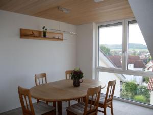 a dining room with a table and chairs and a large window at Ferienwohnung Haus Maria in Wäschenbeuren