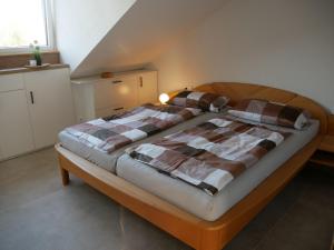 a bedroom with a bed with a plaid blanket at Ferienwohnung Haus Maria in Wäschenbeuren +18 photos