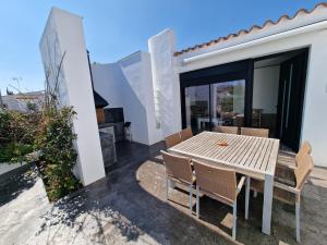 a patio with a wooden table and chairs on a house at VILLA CALA LLARGA BEACH in Roses