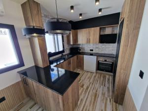 a kitchen with wooden cabinets and a black counter top at VILLA CALA LLARGA BEACH in Roses