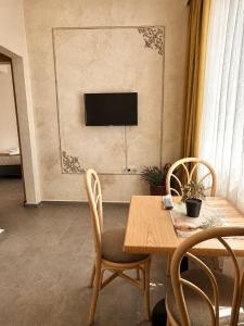 a dining room with a table and a television on a wall at Port Lake Hotel in Beloslav