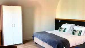 a bedroom with a large bed and a closet at Villa Amylia & gratis parking in Wenduine