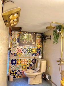 a bathroom with a toilet and a colorful tile wall at Old House Homestay in Hanoi +39 photos