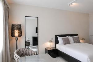 a bedroom with a bed and a mirror and a chair at VISIONAPARTMENTS Freyastrasse - self check-in in Zurich +45 photos