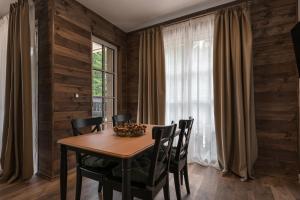 a dining room with a table and chairs and a window at Motherland Chalets in Žabljak