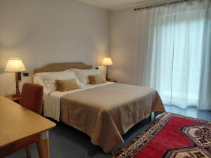 a bedroom with a bed and a table and a window at B&B Piazza Marconi in Castelpizzuto