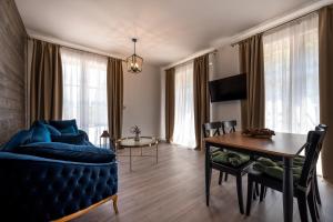 a living room with a blue couch and a table at Motherland Chalets in Žabljak