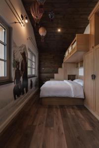 a bedroom with a large bed and a staircase at Motherland Chalets in Žabljak