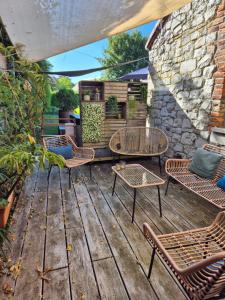 a patio with chairs and tables on a wooden deck at Chambre de Camille à Gerpinnes in Gerpinnes