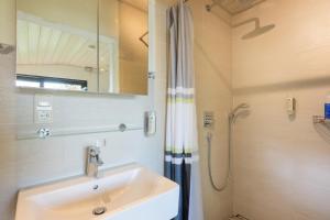 a bathroom with a sink and a shower at Dreimäderlhaus - Das vegetarische Boutique Hotel in Füssen +59 photos
