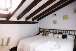 two beds in a room with wooden ceilings at Apartamentos Nevandi in Pido