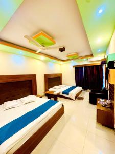 a hotel room with two beds and a tv at Hotel Impulse Ocean View in Cox's Bazar