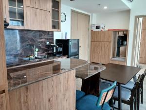 a kitchen with wooden cabinets and a counter top at Marina vinhomes in Long Bình